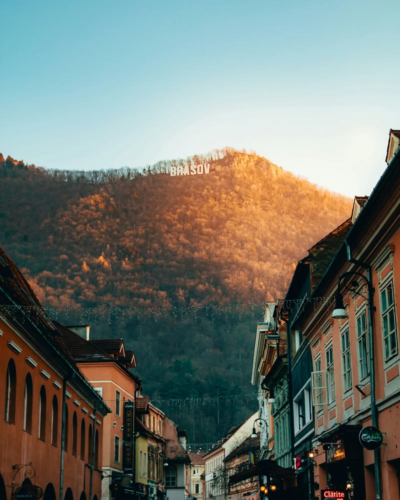 Brașov old town street with the Carpathian mountains rising behind it
